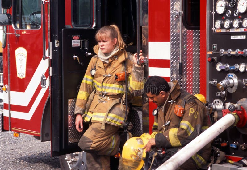 Deux sapeurs-pompiers font une pause après le combat d'un feu de maison images stock Deux sapeurs-pompiers font une pause après le combat d'un feu de maison images stock