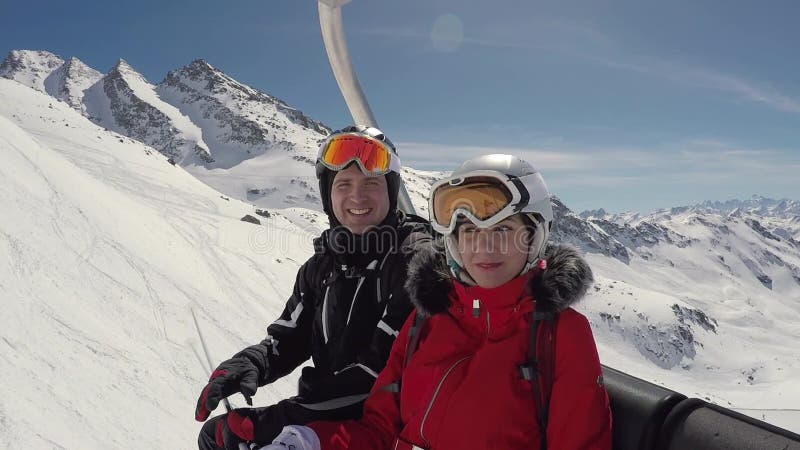 Deux skieurs drôles dupant se reposer autour sur Ski Lift In Winter Mountain