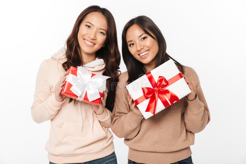 Deux soeurs mignonnes asiatiques de dames tenant la surprise de boîte-cadeau image stock Deux soeurs mignonnes asiatiques de dames tenant la surprise de boîte-cadeau image stock
