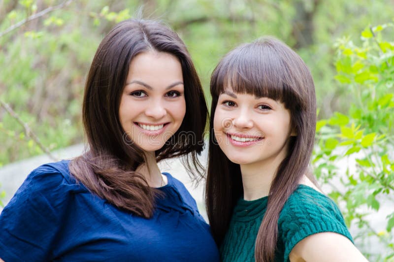 Deux soeurs ou d'amie souriant, riant et étreignent dehors au printemps ou été photo libre de droits Deux soeurs ou d'amie souriant, riant et étreignent dehors au printemps ou été photo libre de droits