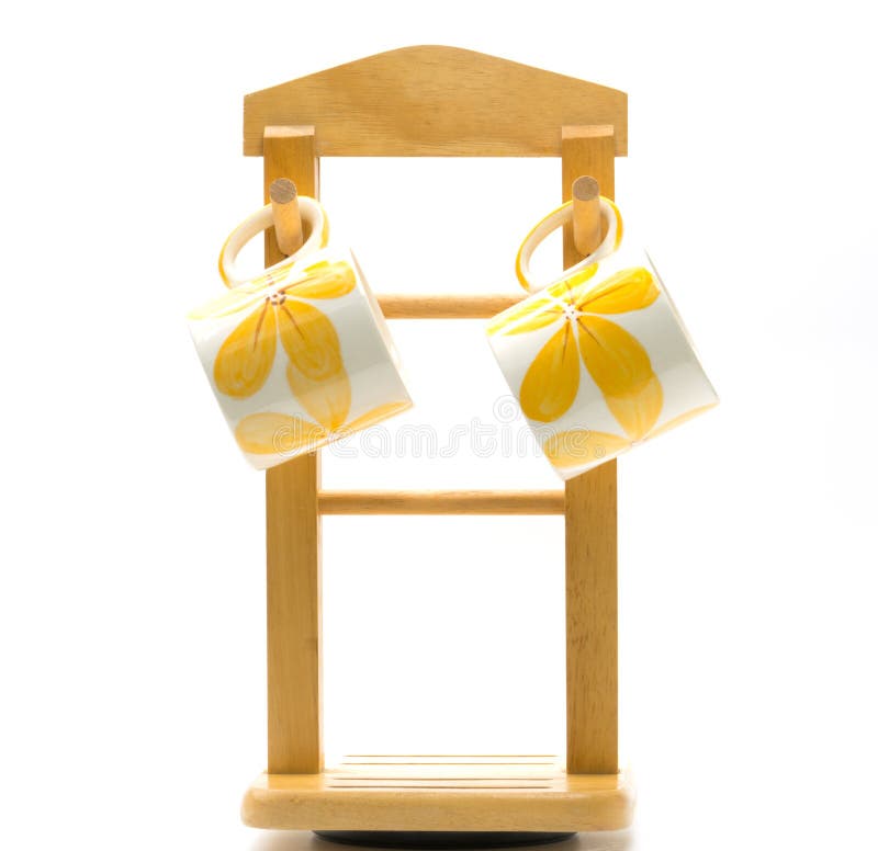 Deux tasses de café est fleur jaune peinte en dehors d'accrocher sur le cintre en bois avec le style minimaliste d'isolement photographie stock Deux tasses de café est fleur jaune peinte en dehors d'accrocher sur le cintre en bois avec le style minimaliste d'isolement photographie stock