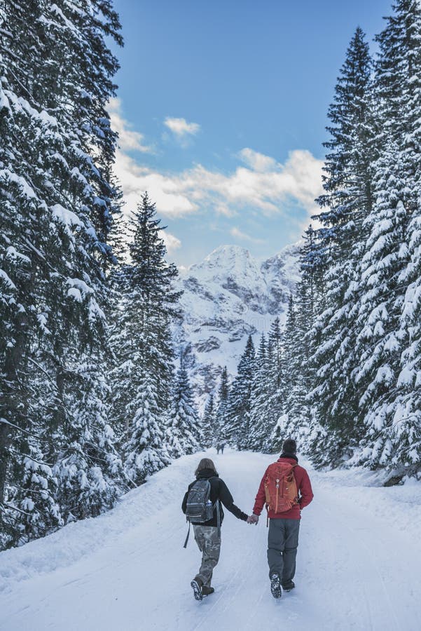 Polish Tatra Mountains, near Zakopane, two tourists walking on road to Morskie Oko lake, Czarny Staw and Rysy in High Tatra Mountains, Poland. Polish Tatra Mountains, near Zakopane, two tourists walking on road to Morskie Oko lake, Czarny Staw and Rysy in High Tatra Mountains, Poland