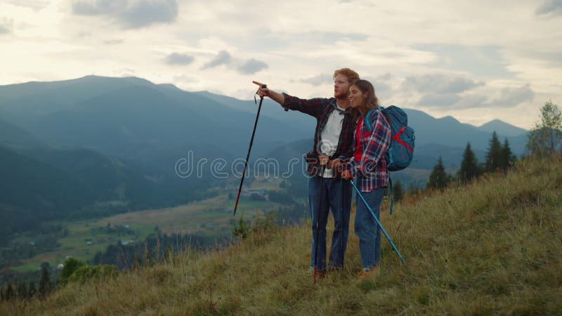 Deux touristes parlent dehors sur la randonnée en montagne. voyageur couple trekking nature. banque de vidéos