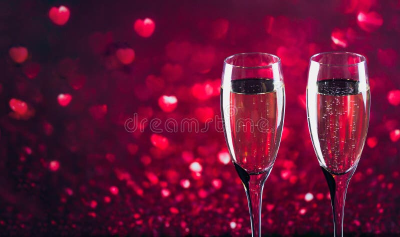 Deux verres de champagne avec le bokeh rouge de forme de coeur sur le fond images libres de droits Deux verres de champagne avec le bokeh rouge de forme de coeur sur le fond images libres de droits