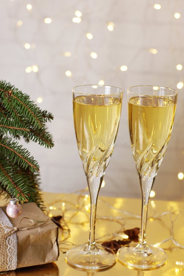 Deux verres de champagne sont sur la table à côté des présents de Noël et de nouvelle année sous l'arbre de Noël photographie stock libre de droits Deux verres de champagne sont sur la table à côté des présents de Noël et de nouvelle année sous l'arbre de Noël photographie stock libre de droits