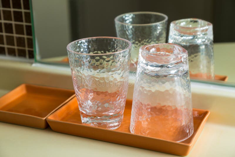 Deux verres à boire clairs dans le plateau en céramique brun images stock Deux verres à boire clairs dans le plateau en céramique brun images stock