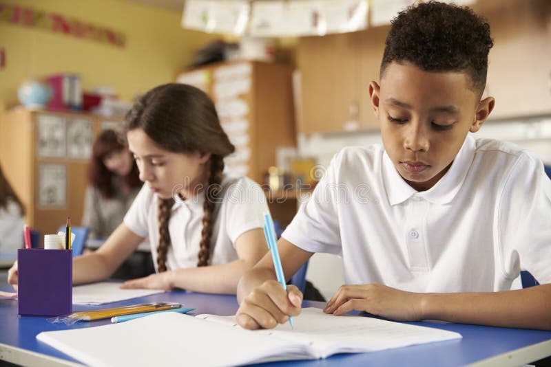 Deux élèves d'école primaire à leurs bureaux dans la classe, se ferment image stock