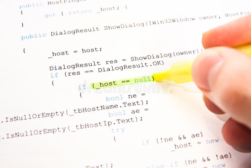 Developer (programmer) highlighting part of code with yellow marker. Developer (programmer) highlighting part of code with yellow marker