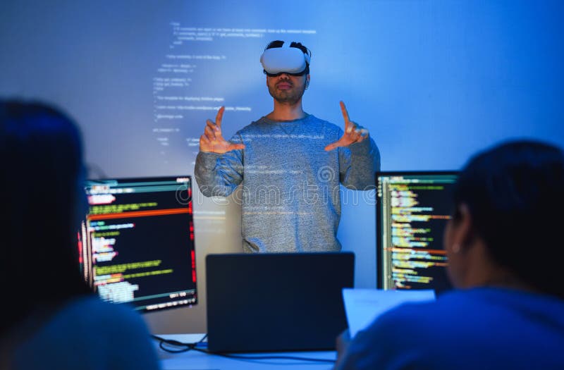 Developer uses a VR headset to interact with projected interface designs, while colleagues discuss and code on screens stock photos