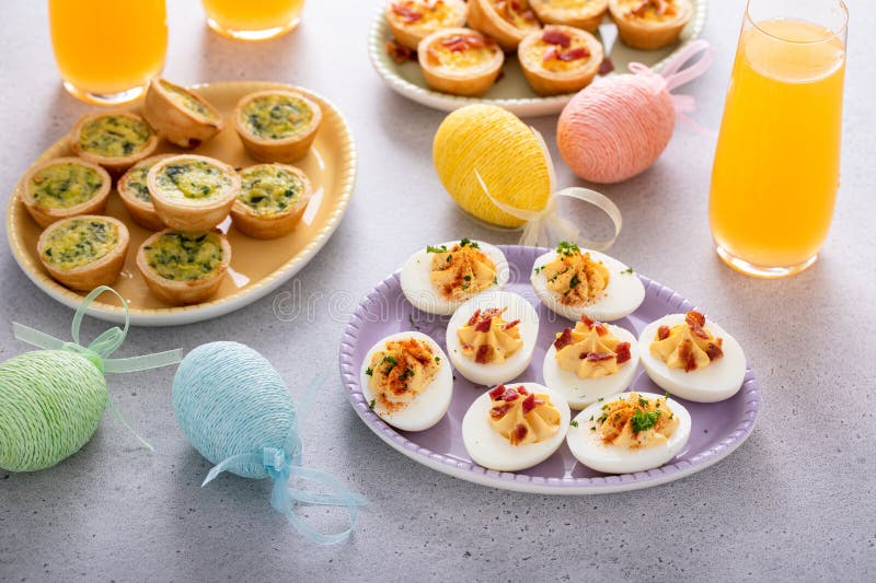 Deviled eggs and mini quiches, appetizers for Easter stock photography