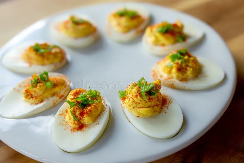 Deviled Eggs with Paprika and Green Onions on a White Egg Platter