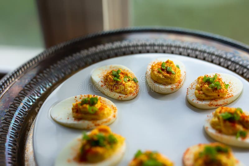 Deviled Eggs with Paprika and Green Onions on a White Egg Platter. Shot