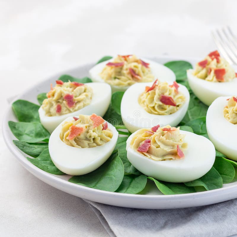 Deviled Eggs Stuffed with Avocado, Egg Yolk and Mayonnaise Filling, Garnished with Bacon on