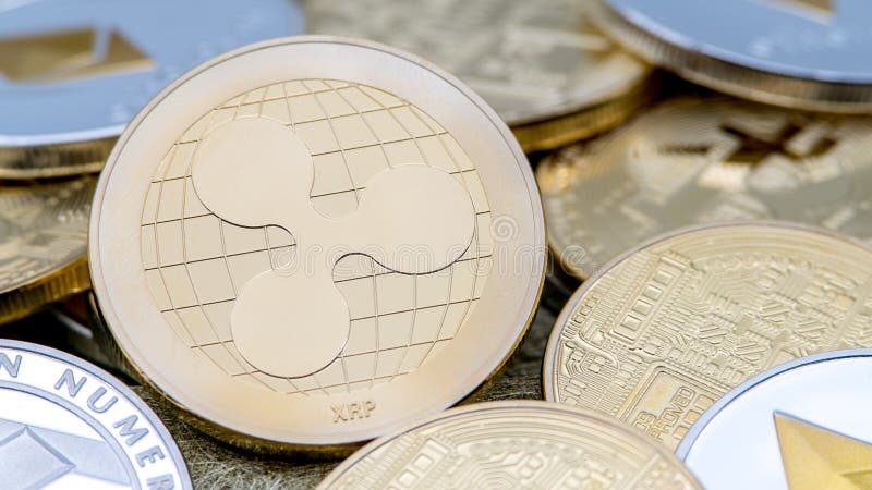 Devise d'or de Ripplecoin en métal physique au-dessus d'autres pièces de monnaie Pi?ce de monnaie d'ondulation photo stock Devise d'or de Ripplecoin en métal physique au-dessus d'autres pièces de monnaie Pi?ce de monnaie d'ondulation photo stock