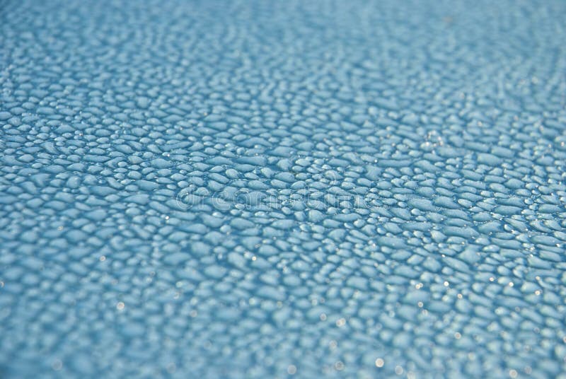 Dew drops on blue metallic surface