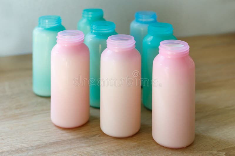 di bottiglie per il latte colorate Multi riempite di latte per l'alimentazione delle capre domestiche sull'azienda agricola immagine stock di bottiglie per il latte colorate Multi riempite di latte per l'alimentazione delle capre domestiche sull'azienda agricola immagine stock
