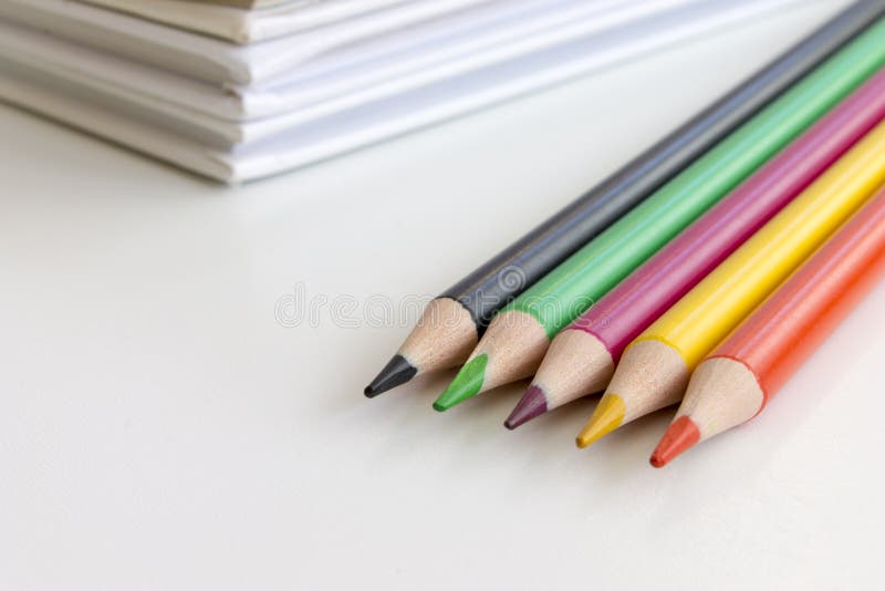 Di nuovo al concetto del banco Matite multicolori con i libri su fondo fotografia stock Di nuovo al concetto del banco Matite multicolori con i libri su fondo fotografia stock