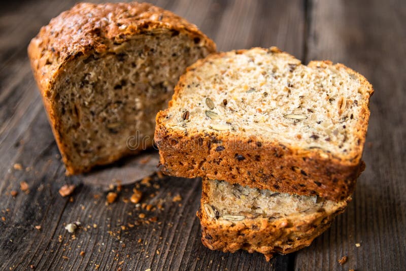 Di recente intero pane organico al forno sano casalingo del grano con i semi sani sulla tavola di legno fotografie stock libere da diritti Di recente intero pane organico al forno sano casalingo del grano con i semi sani sulla tavola di legno fotografie stock libere da diritti