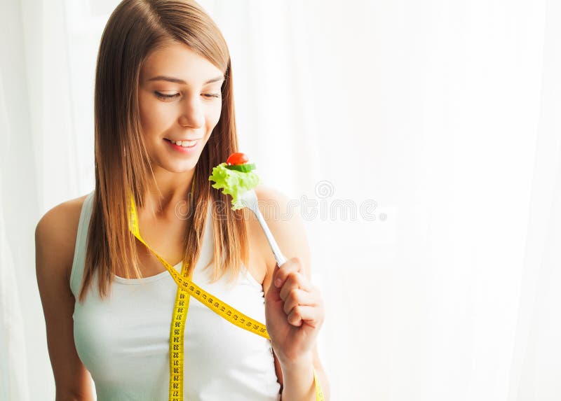 Di?t und gesundes Essen Junge Frau, die gesunden Salat nach Training isst lizenzfreies stockbild Di?t und gesundes Essen Junge Frau, die gesunden Salat nach Training isst lizenzfreies stockbild