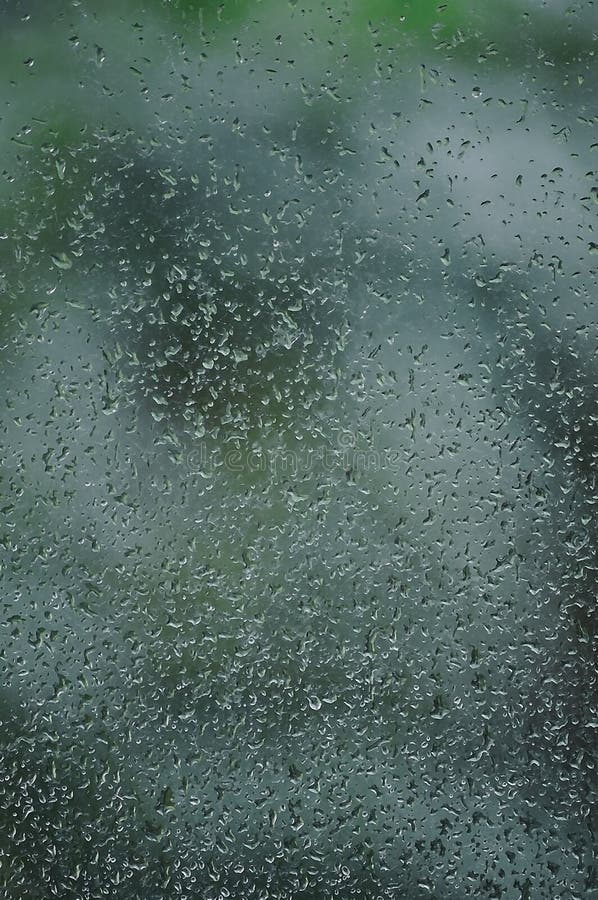 Dia chuvoso, pingos de chuva no vidro de janela molhado, detalhe abstrato brilhante vertical do teste padrão do fundo da água de