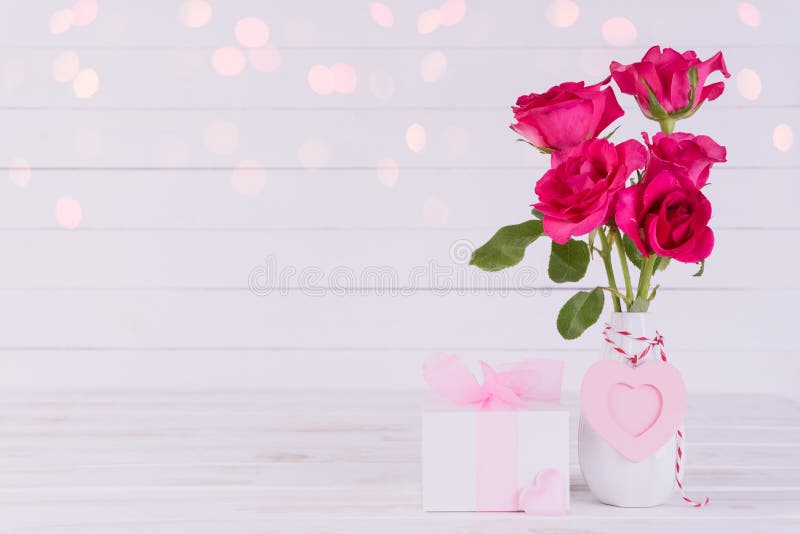 Dia de Valentim e conceito do amor Rosas cor-de-rosa no vaso com coração de madeira e na caixa de presente no fundo de madeira br imagem de stock royalty free Dia de Valentim e conceito do amor Rosas cor-de-rosa no vaso com coração de madeira e na caixa de presente no fundo de madeira br imagem de stock royalty free