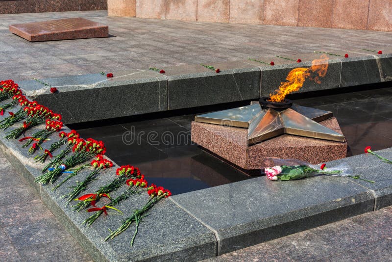 Victory day on 9 may, carnations flowers at eternal fire monument in honor or memory of the fallen soldiers in the great World War II 1941-1945. Grave of Unknown soldier in Russia, Samara. Victory day on 9 may, carnations flowers at eternal fire monument in honor or memory of the fallen soldiers in the great World War II 1941-1945. Grave of Unknown soldier in Russia, Samara