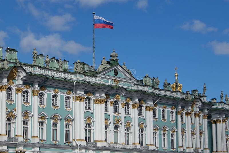 Dia ensolarado em St Petersburg, voo da bandeira do russo acima da fachada do museu do estado do eremitério