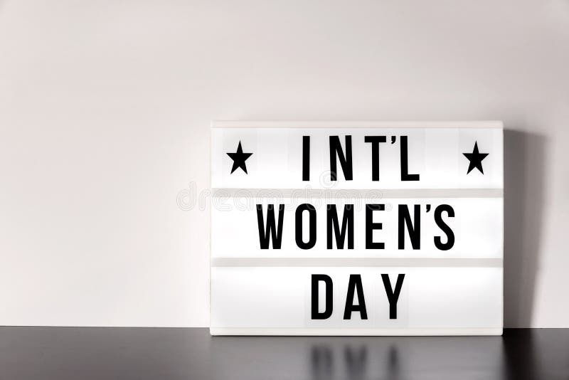 Dia internacional do ` s das mulheres - conceito - caixa leve com rotulação do estilo do cinema no fundo branco imagens de stock Dia internacional do ` s das mulheres - conceito - caixa leve com rotulação do estilo do cinema no fundo branco imagens de stock