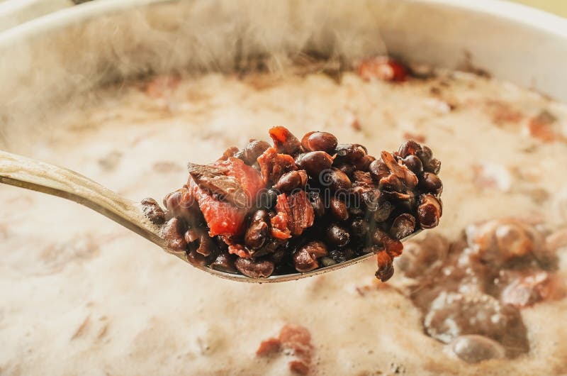 Dia la presa a cucchiaiate dagli ingredienti della pentola di Feijoada fotografia stock libera da diritti Dia la presa a cucchiaiate dagli ingredienti della pentola di Feijoada fotografia stock libera da diritti