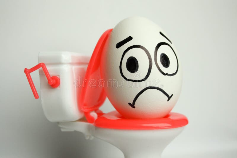 Diarrhea and pain a comical concept. the egg with the painted face is sad and sits on the toilet. photo for your design. vertical orientation. Diarrhea and pain a comical concept. the egg with the painted face is sad and sits on the toilet. photo for your design. vertical orientation