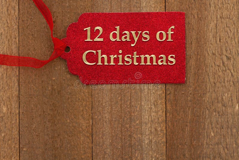 12 day of Christmas message on red gift tag on weathered wood with a ribbon with space for your suggestions. 12 day of Christmas message on red gift tag on weathered wood with a ribbon with space for your suggestions