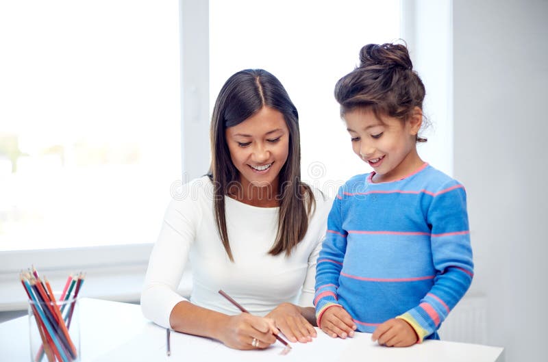 Dibujo feliz de la madre y de la hija con los lápices fotografía de archivo Dibujo feliz de la madre y de la hija con los lápices fotografía de archivo