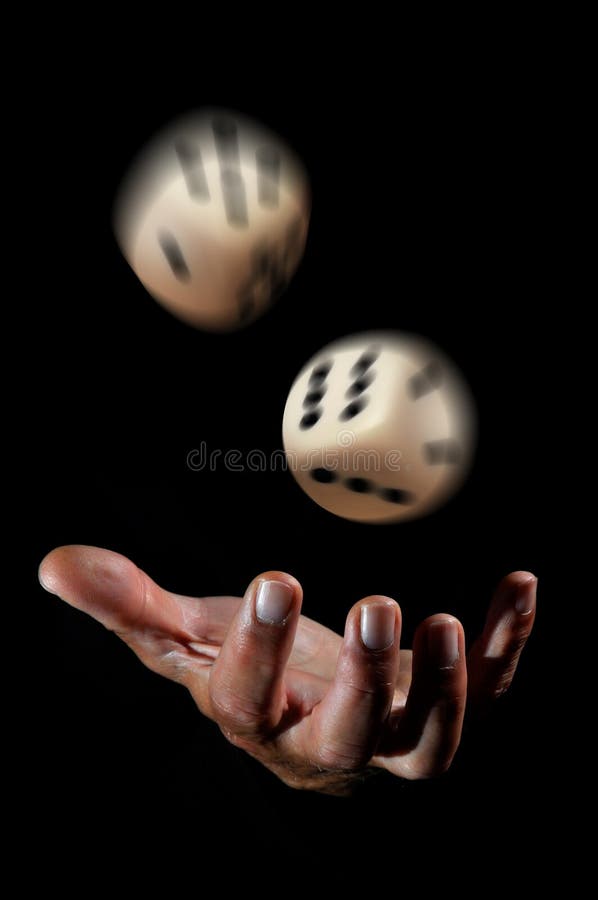 Hand throwing dice in a dark background royalty free stock photography.