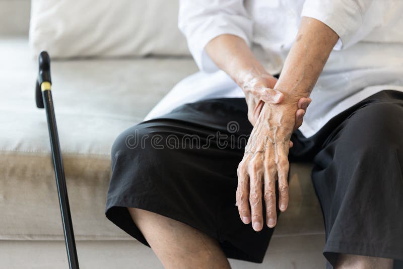 Dicht in het uitzicht op de schudhand van de oudere vrouw, symptoom van rusttremor of ziekte van parkinson, bejaarde patiënte in