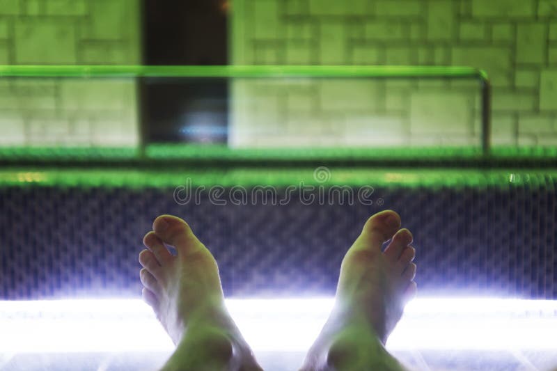 Dichte omhooggaand van de blootvoetse mens die dichtbij binnenluxe zwembad liggen Een schot van jonge man voeten bij de binnenpoo royalty-vrije stock foto Dichte omhooggaand van de blootvoetse mens die dichtbij binnenluxe zwembad liggen Een schot van jonge man voeten bij de binnenpoo royalty-vrije stock foto
