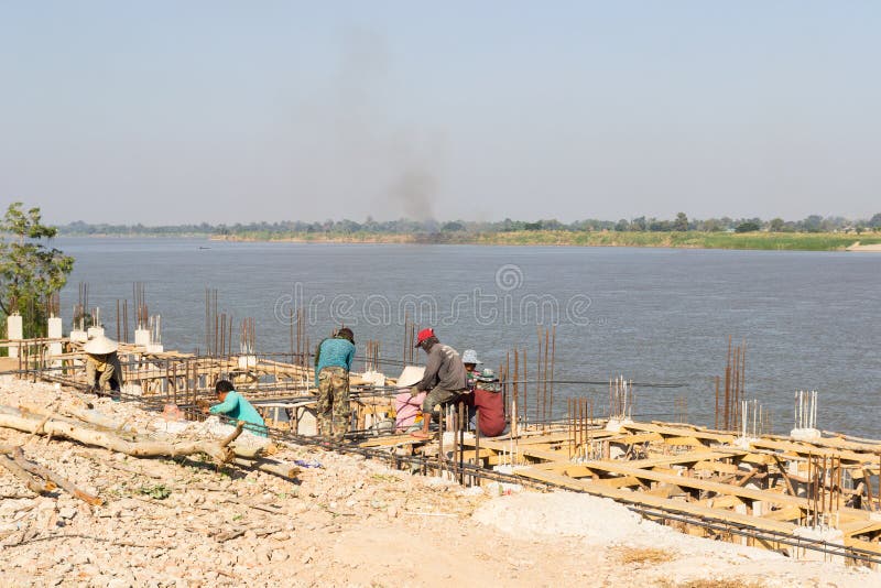 Die Arbeitskräfte konstruieren den Pier neben dem Mekong nahe t lizenzfreie stockfotos Die Arbeitskräfte konstruieren den Pier neben dem Mekong nahe t lizenzfreie stockfotos