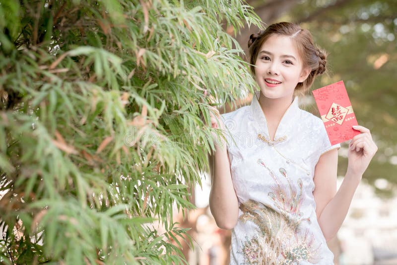 Die Asiatin auf Chinesisch kleiden das Halten des Distichons 'glücklich' (Rippenstück lizenzfreie stockfotos Die Asiatin auf Chinesisch kleiden das Halten des Distichons 'glücklich' (Rippenstück lizenzfreie stockfotos