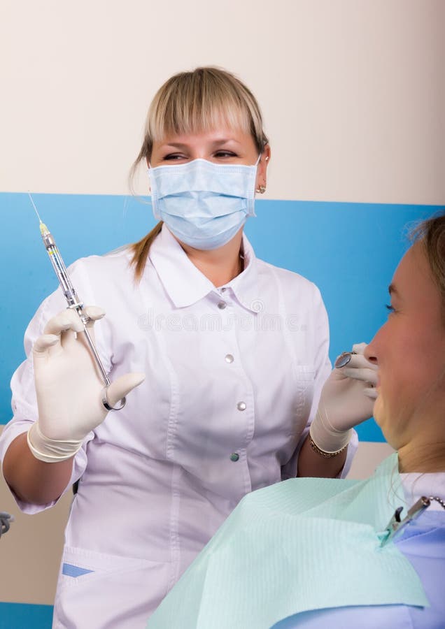 Die Aufnahme war am weiblichen Zahnarzt, den Doctor die Mundhöhle auf Zahnverfall überprüft lizenzfreie stockbilder Die Aufnahme war am weiblichen Zahnarzt, den Doctor die Mundhöhle auf Zahnverfall überprüft lizenzfreie stockbilder