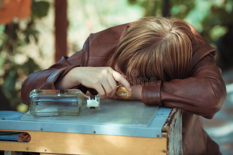 Die betrunkene Frau, die auf eine Tabelle einschlief lizenzfreies stockbild Die betrunkene Frau, die auf eine Tabelle einschlief lizenzfreies stockbild