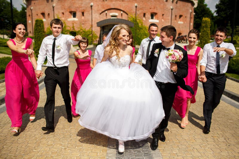 Die Brautjungfern und Groomsmen haben Spaß gehend um den Park mit stockfoto Die Brautjungfern und Groomsmen haben Spaß gehend um den Park mit stockfoto