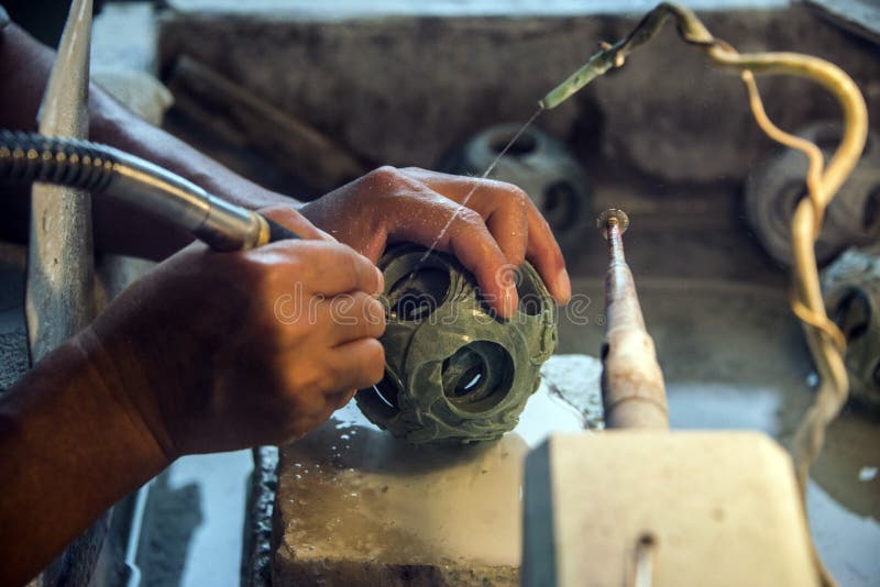 Die chinesische Handwerkertranchiermesserhand, die einen runden Jadepuzzlespielball nannte schnitzt auch, einen Generations-Ball, stockfotografie Die chinesische Handwerkertranchiermesserhand, die einen runden Jadepuzzlespielball nannte schnitzt auch, einen Generations-Ball, stockfotografie