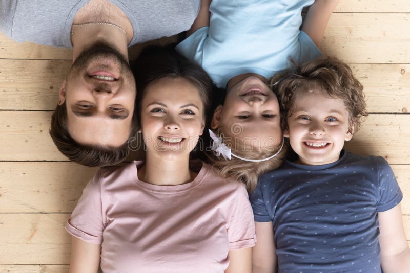 Die Eltern der kleinen Kinder, die sich auf dem Holzboden befinden lizenzfreie stockfotografie