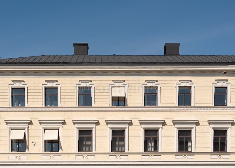 Die Fassade des Stadtgebäudes, -windows und -dachs gegen den blauen Himmel stockfoto Die Fassade des Stadtgebäudes, -windows und -dachs gegen den blauen Himmel stockfoto