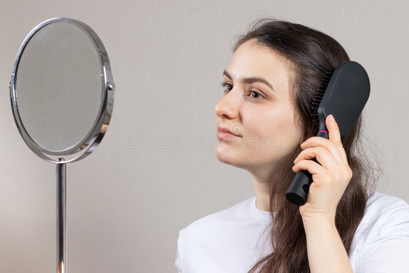 Die Frau Bürstet Ihr Haar Und Lächelt Vor Dem Spiegel Sitzend. Pflege Der  Langen Haare. Stockbild - Bild von hygiene, schönheit: 217273213