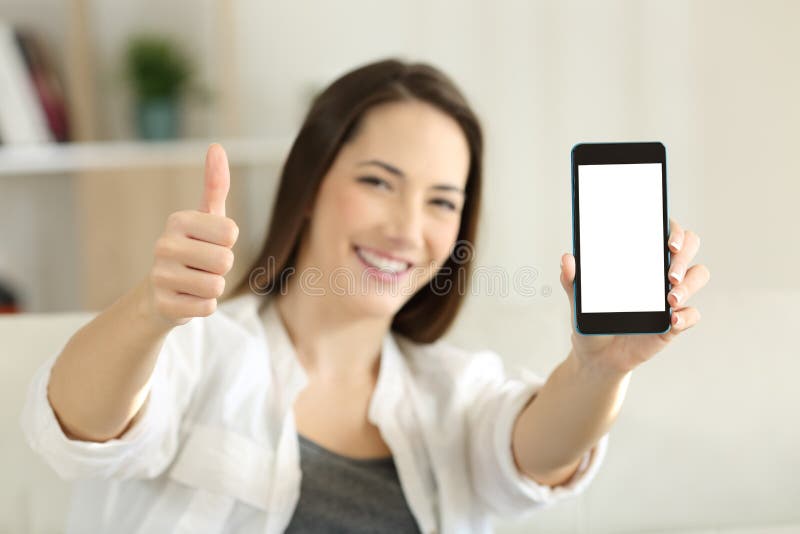 Die Frau, die ein leeres intelligentes Telefon zeigt, sortieren zu Hause aus lizenzfreie stockfotos Die Frau, die ein leeres intelligentes Telefon zeigt, sortieren zu Hause aus lizenzfreie stockfotos
