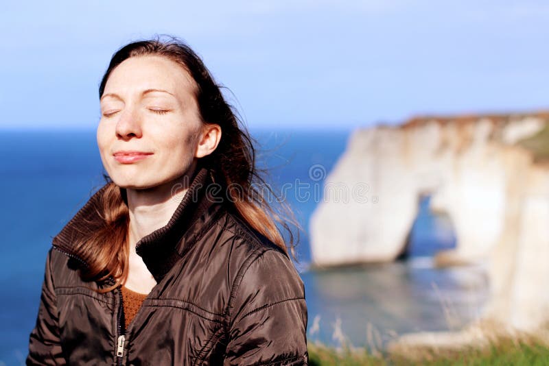 Die Frau, die lächelt, Atem tuend, trainiert auf Normandie-Klippen im Frühjahr