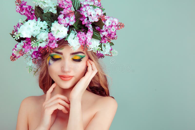 Die Frau, die mit Blumen auf gelbem und grünem Hauptlidschatten lächelt, schloss Augen lizenzfreie stockfotografie Die Frau, die mit Blumen auf gelbem und grünem Hauptlidschatten lächelt, schloss Augen lizenzfreie stockfotografie
