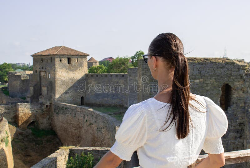 Die Frau in weißer Bluse im Hintergrund der defensiven Steinwände. lizenzfreies stockfoto