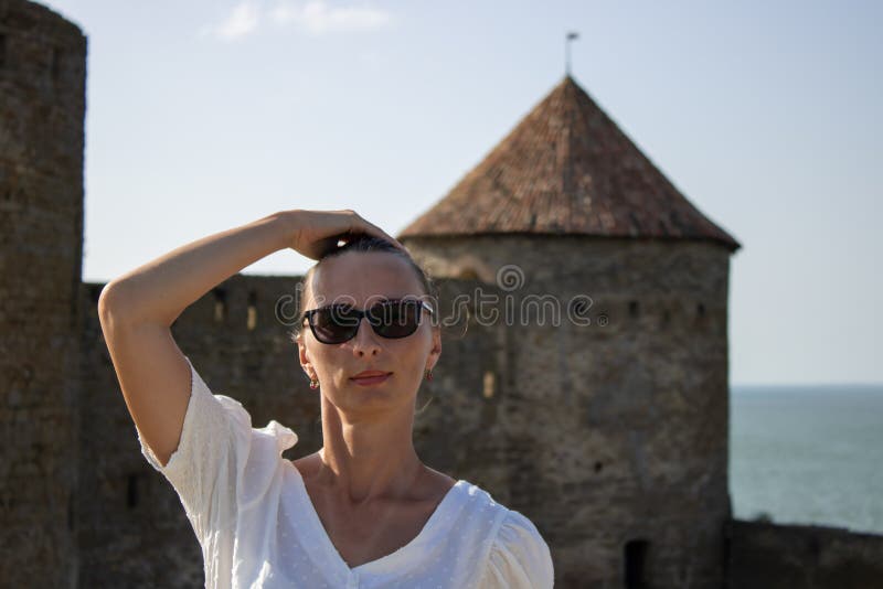 Die Frau in weißer Bluse im Hintergrund der defensiven Steinwände. stockfotografie