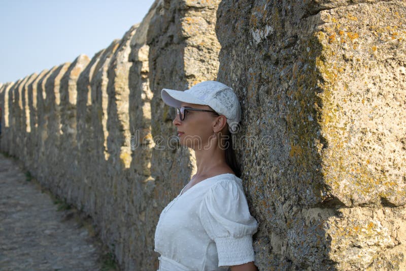 Die Frau in weißer Bluse im Hintergrund der defensiven Steinwände. lizenzfreies stockfoto